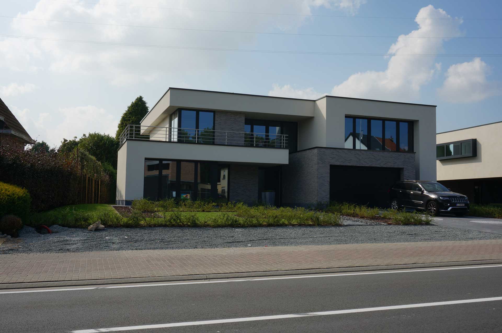 Moderne woning met grote aluminium ramen en donkere accenten aan de gevel<br />
Moderne woning met grote aluminium ramen en donkere accenten aan de gevel<br />
