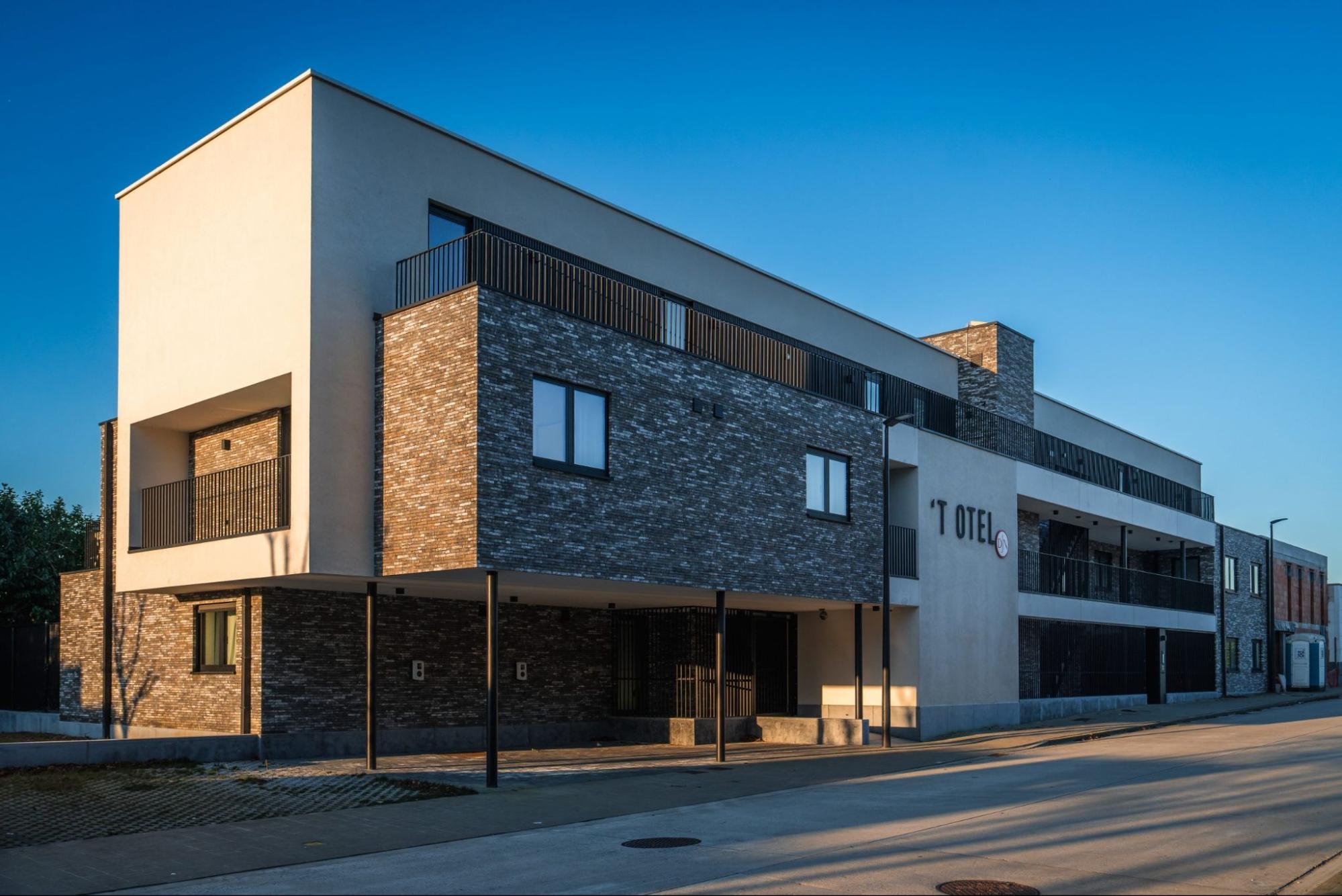 Modern appartementsgebouw met grote ramen en slanke profielen in donkere tint
