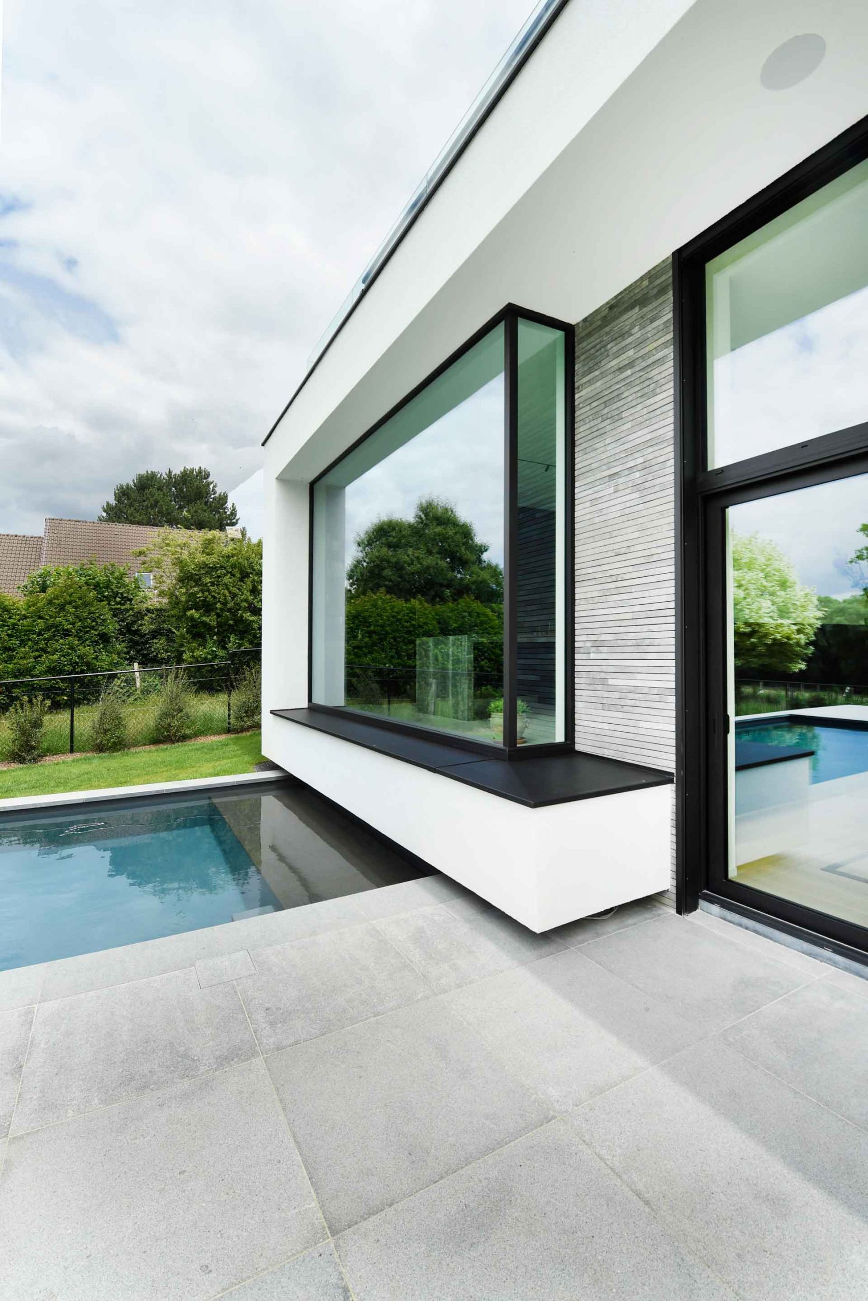 Moderne gevel met grote hoekraam en slanke zwarte aluminium profielen voor maximaal licht en een strakke look