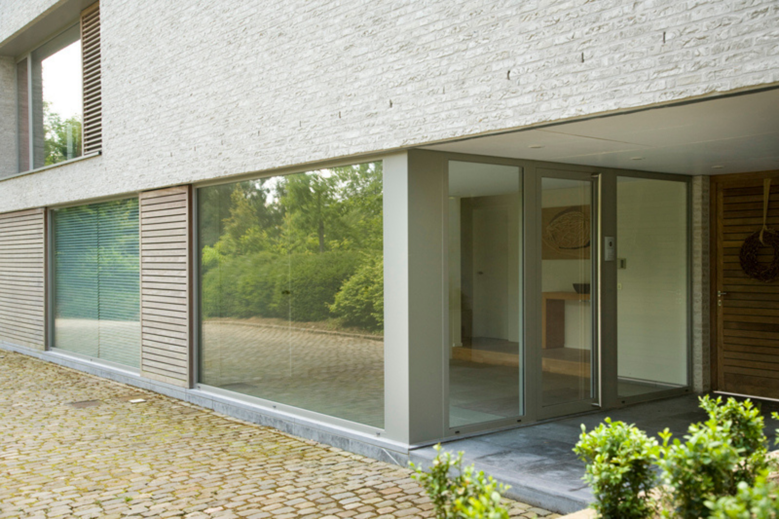 Buitendeur op maat in aluminium met grote glaspartijen voor een hedendaagse woning