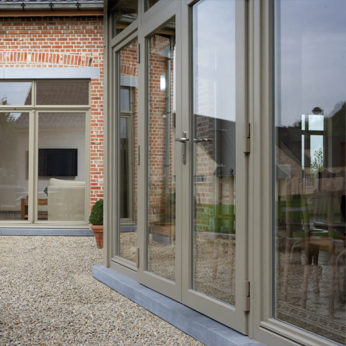 Pvc buitendeur met glas en klassieke uitstraling aan een woning in baksteen