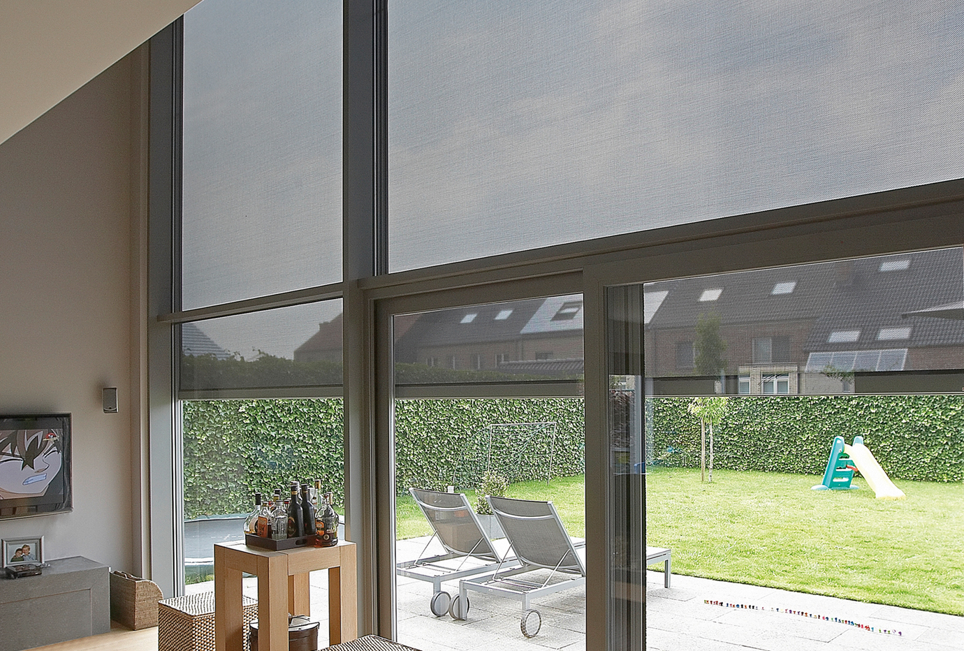 Grote aluminium ramen met screens die zonlicht filteren en uitkijken op de tuin