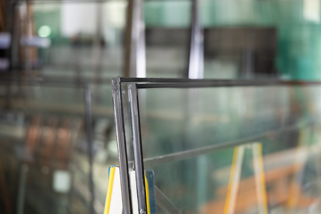 Doorsnede van dubbele beglazing met zwarte afstandhouder, gefotografeerd in een glazenwerkplaats.